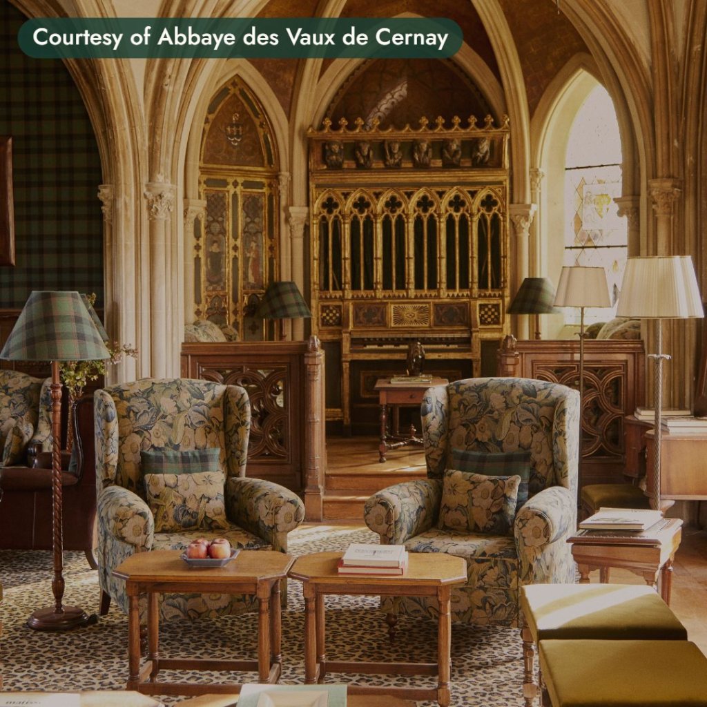 A vaulted Gothic lounge with armchairs and a carved wooden screen in a French abbey hotel. Courtesy of Abbaye des Vaux de Cernay.
