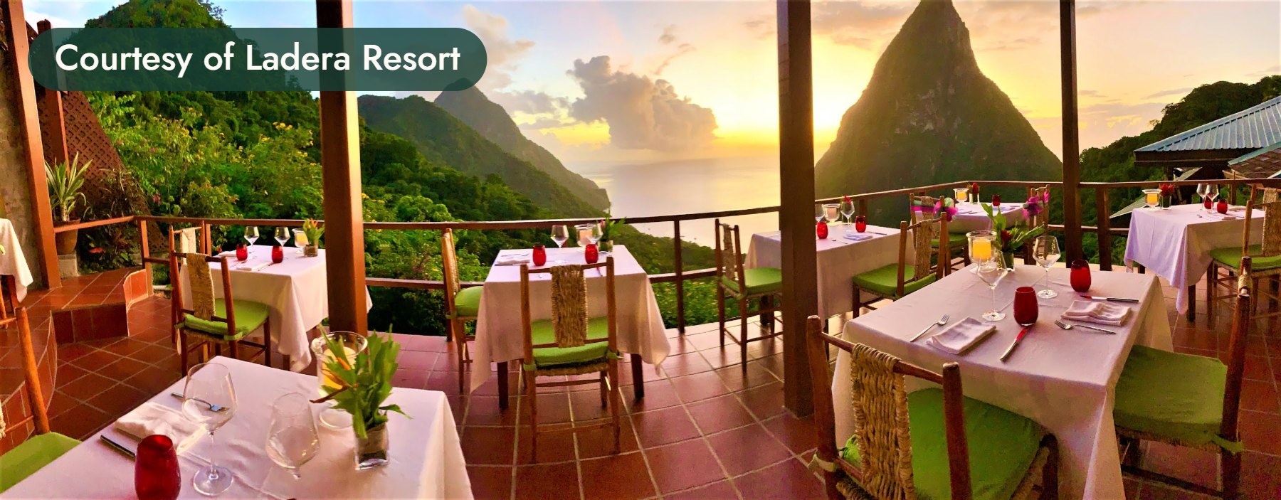Tables set on an open-air terrace at sunset, with the Pitons rising beyond. Courtesy of Ladera Resort.